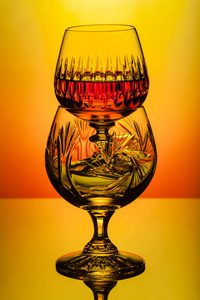 朗姆酒，威士忌在玻璃桌，彩色背景的卡拉夫瓶水晶眼镜