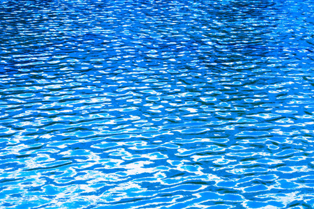 s reflection. The blue water swimming pool with sun reflections