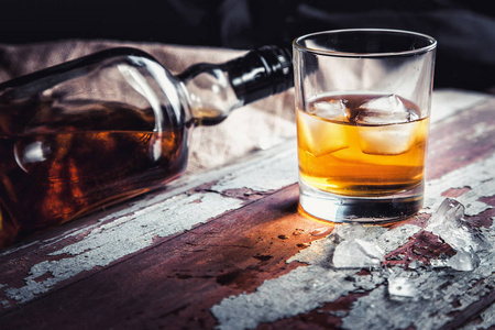 威士忌酒瓶和酒杯木制老式背景上