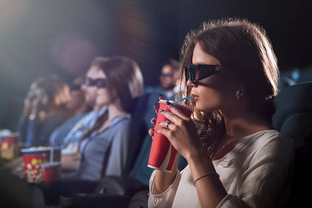 年轻漂亮的女人在电影院看电影照片