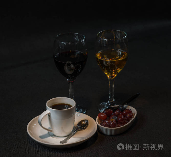 红葡萄酒和白葡萄酒在玻璃与葡萄在陶瓷碗