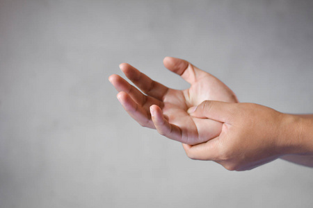 女性疥疮灰色背景的人抓痒手的特写照片