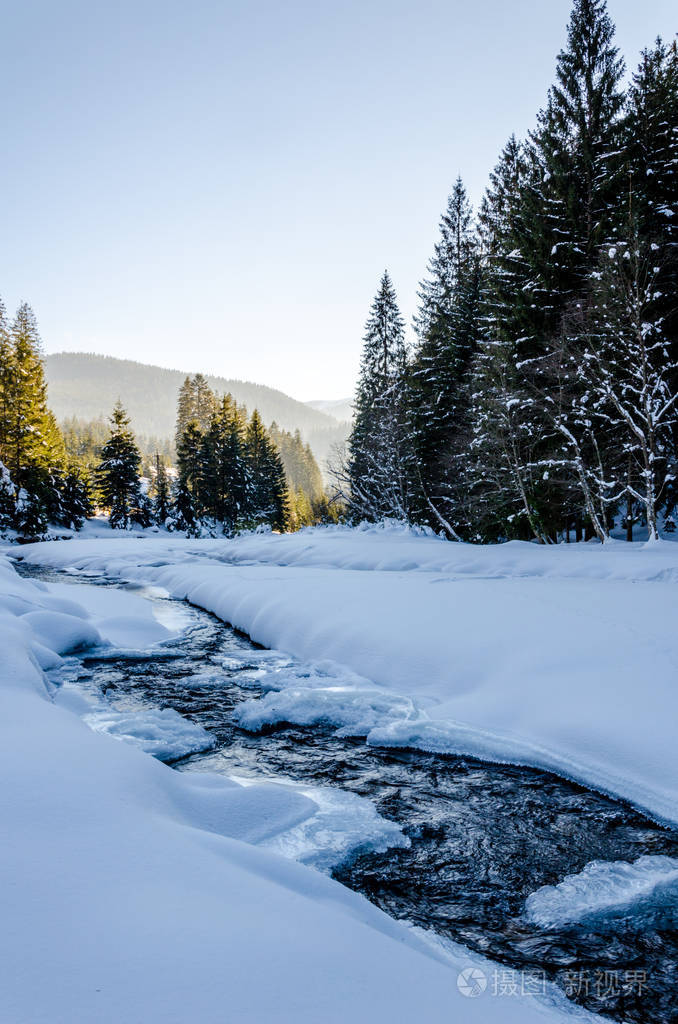 冬天的山风景, 冰冻的河流覆盖着雪的流动