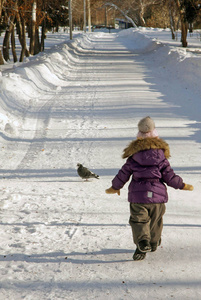 孩子在雪冬天公园跑淡紫色冬天衣服