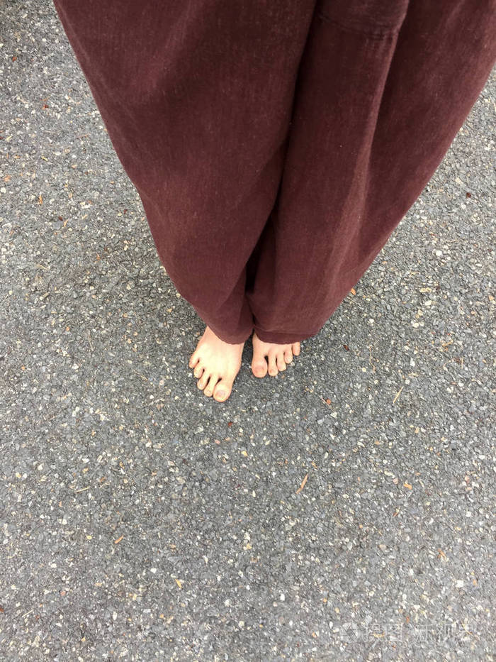 妇女的躺式裤子和赤脚在石头地面背景照片-正版商用图片0xo29q-摄图新