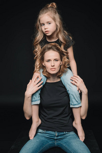 女儿坐在母亲的肩膀上图片