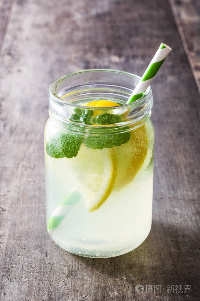 在木制背景上一罐杯喝柠檬水copyspace