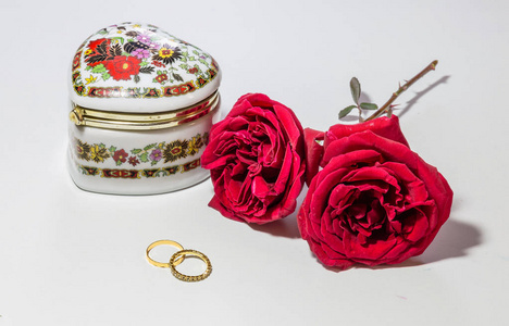 浪漫的爱情安装用鲜亮的红色玫瑰金的订婚戒指与浅色背景艺术首饰盒