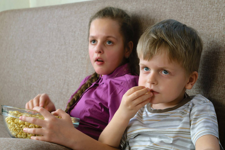 男孩与姐姐看着爆米花部有趣的电影
