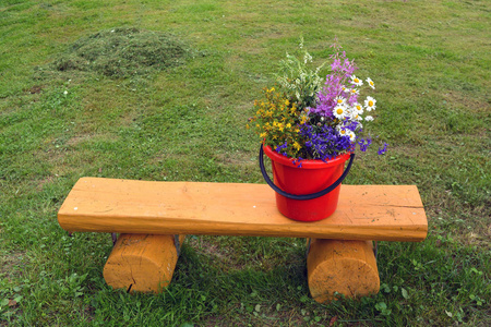 在黄色的木凳上的各种夏季野花花束