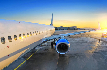 停车终端在入口处,日出和在机场发动机停车乘客的飞机视图照片