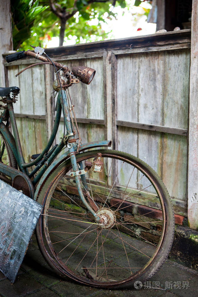 老锈迹斑斑的坏自行车站在大街上