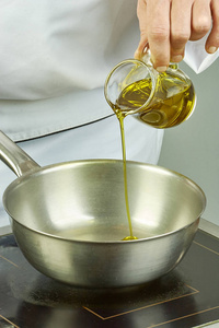 厨师倒油放进锅中烹饪系列充分烹饪食物食谱照片