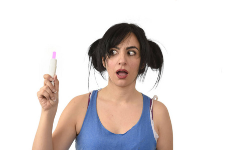 年轻孕妇害怕检查妊娠试验的粉红色积极结果的震惊