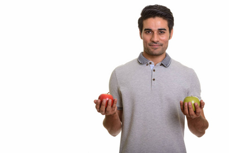 年轻快乐的波斯人，拿着红色和绿色的苹果