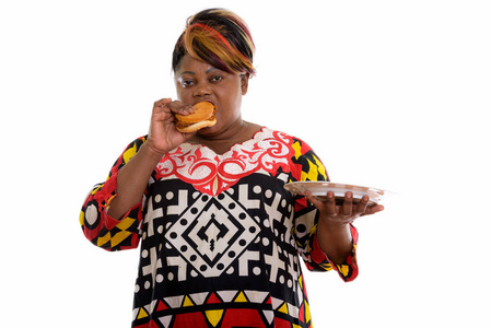 工作室拍摄的胖黑色非洲女人吃汉堡时 holdi