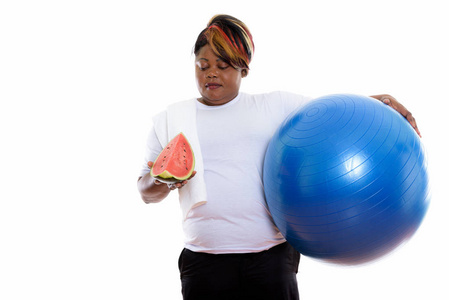 工作室拍摄的胖黑色非洲女人抱着锻炼球和