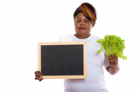 工作室拍摄的胖黑色非洲女人抱着生菜和空白
