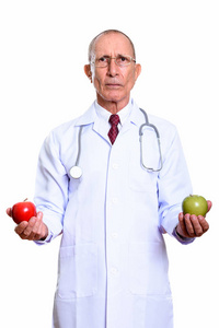 工作室拍摄的高级的男医生拿着红红的苹果和绿色的应用程序