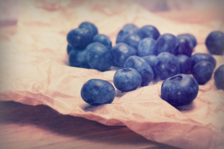 质朴的棕色纸张背景上的新鲜蓝莓