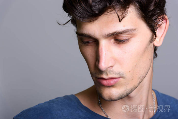 年轻英俊的男人,同时低头思考的特写