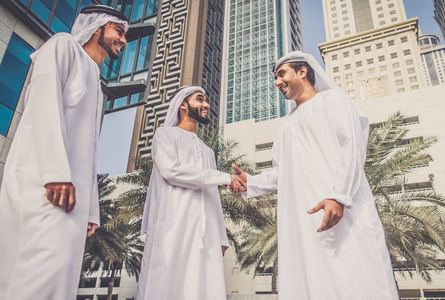 大胡子阿拉伯男子走在迪拜的阿拉伯商人照片