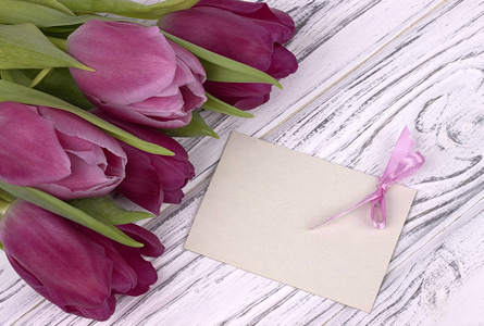 用白纸白色木制背景与文本的卡上的紫色郁金香。女人的一天。3 月 8 日。母亲节