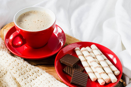 卡布奇诺咖啡和巧克力在床上与格子