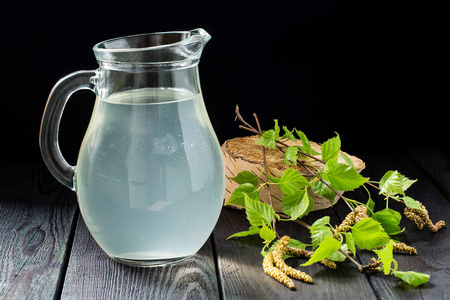 白桦树的分支新鲜的桦树汁在水罐和白桦树的分支机构照片