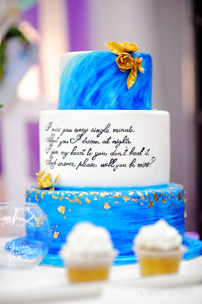 在婚宴上设置与蓝色蛋糕和纸杯蛋糕的甜蜜表