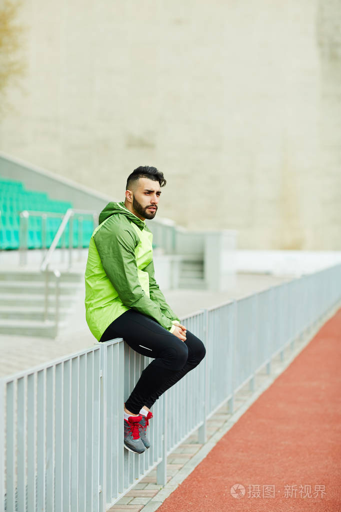 男人坐在栏杆上休息