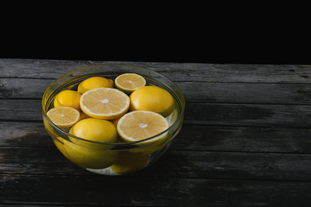 一束切割和整个柠檬和葡萄柚在一个碗里装满了水