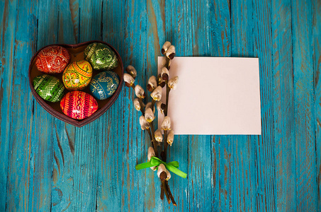 花束柳枝和复活节彩蛋木制的桌子上