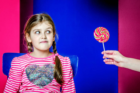 一个小女孩感兴趣地看着正在给她的糖果
