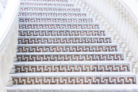 用马赛克铺成与栏杆的白色楼梯。抽象的古典建筑室内片段