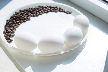在白色盘子上的月亮形状的咖啡豆, 有三个鸡蛋