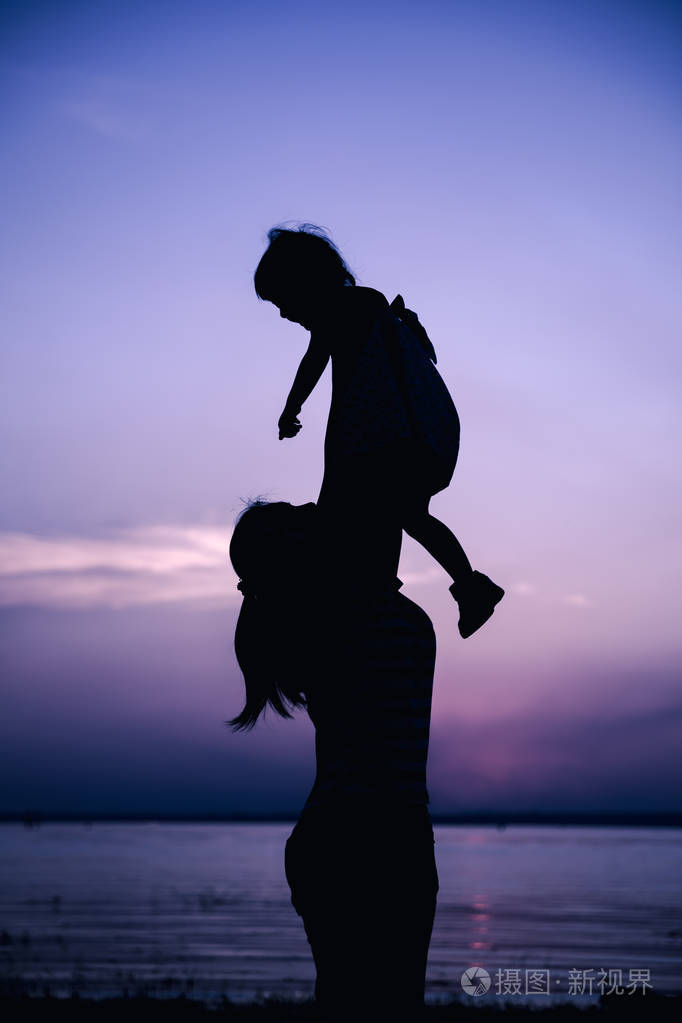 母亲和儿童享受着在河畔景色的轮廓