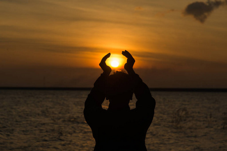 手与夕阳的剪影