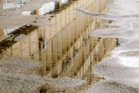 雨淋时在城市街道上的水坑倒影照片