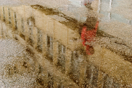 雨淋时在城市街道上的水坑倒影照片