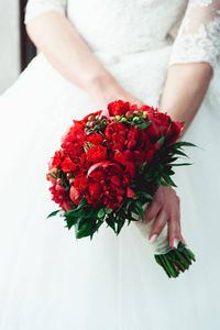 在举行婚礼花束的豪华婚纱新娘做的红玫瑰和牡丹