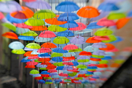 作为挂在露天的街头装饰明亮五颜六色的雨伞