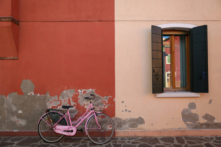 粉色自行车靠在墙上图片