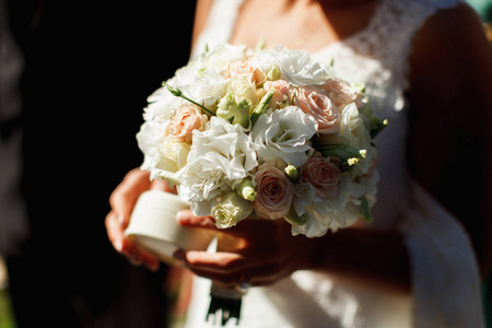 一束白色和粉红色的花是由新娘举行