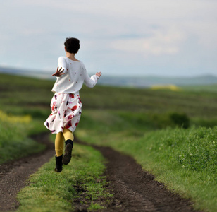 在乡村路的裙子奔跑的妇女