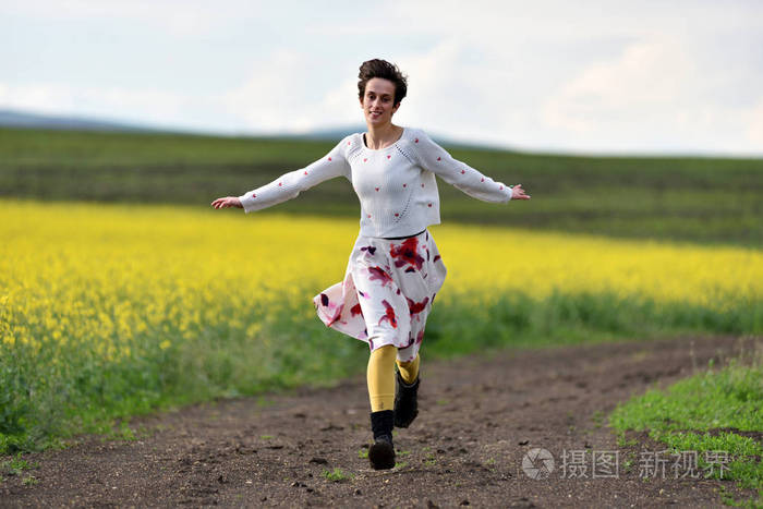 在乡村公路上奔跑的微笑的妇女