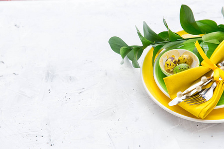 节日餐桌布置和装饰着鲜花在绿色和黄色。复活节背景