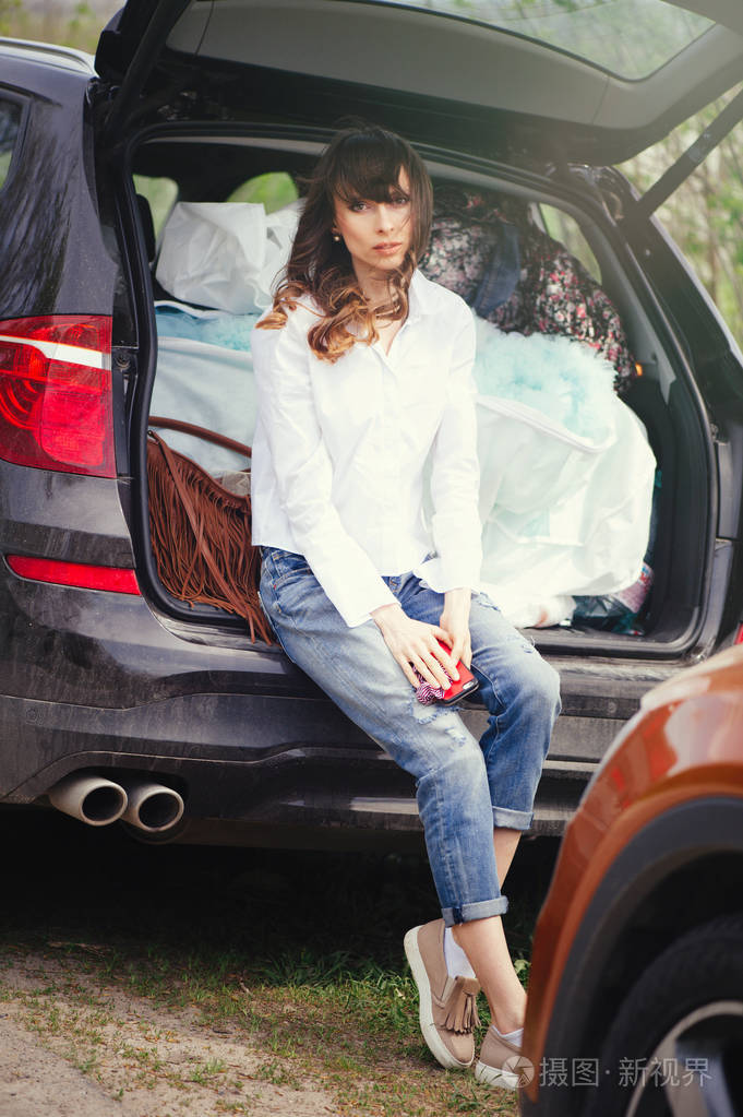 坐在汽车后备箱里的美女