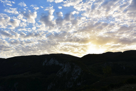 夕阳山与美丽的阳光透过云层背后