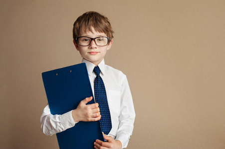 聪明的男孩,在优雅的西装,坐在一片纸的切斯特菲尔德沙发上的眼镜.